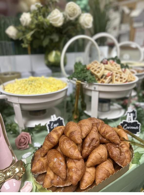 Flavor and Flair Catering luxury brunch spread featuring golden croissants, scrambled eggs, and fresh waffles with white roses