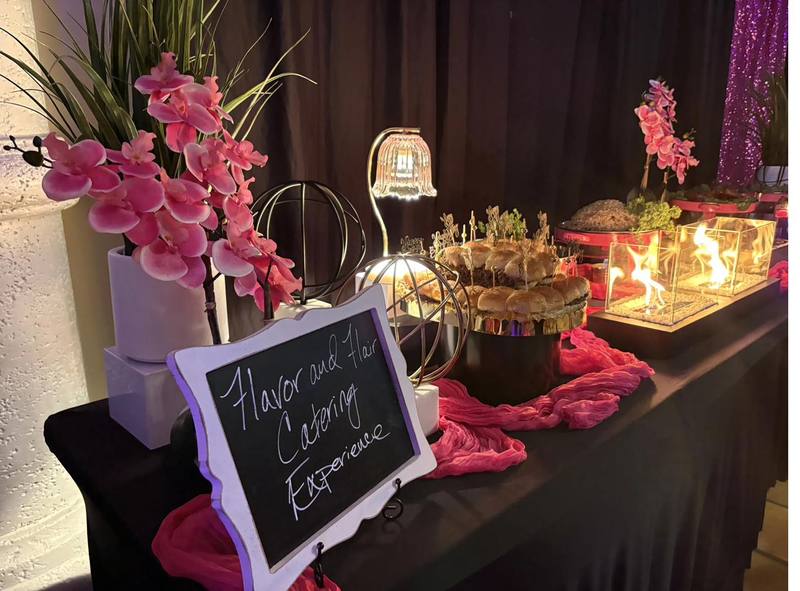Flavor and Flair Catering buffet setup with pink orchids, candles, and sliders