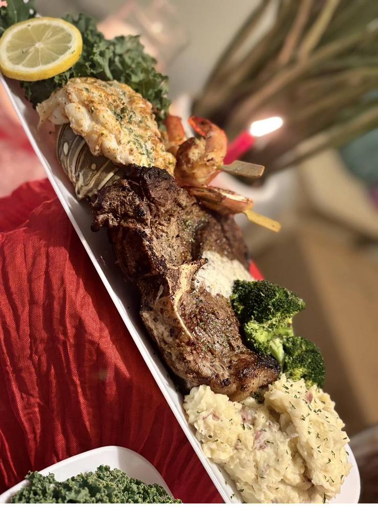 Flavor and Flair Catering gourmet spread with lobster tail, steak, shrimp skewers, and broccoli